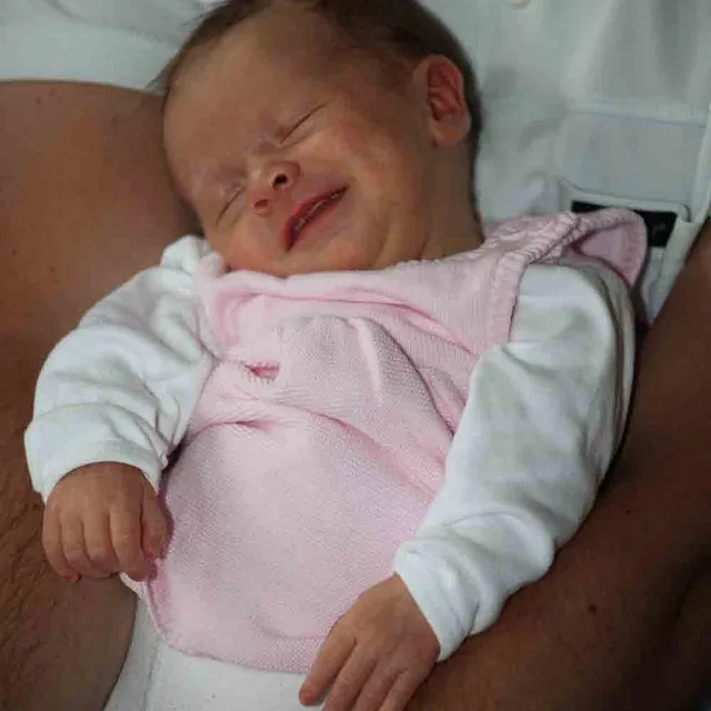 Baby i rosa og hvite klær