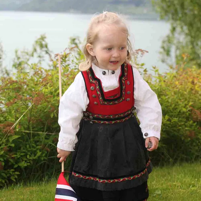 Jente i bunad holder flagg